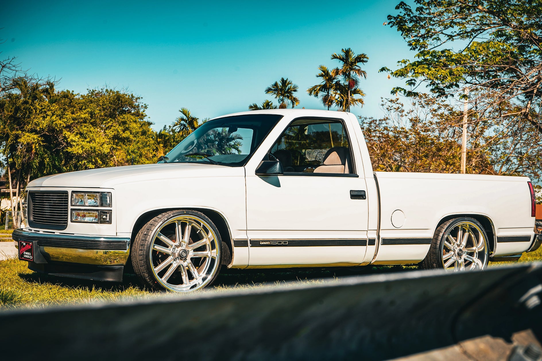 Polished w/textured gunmetal finish multi-spoke wheel fitment on lowered white GMC OBS 1500 single-cab pickup